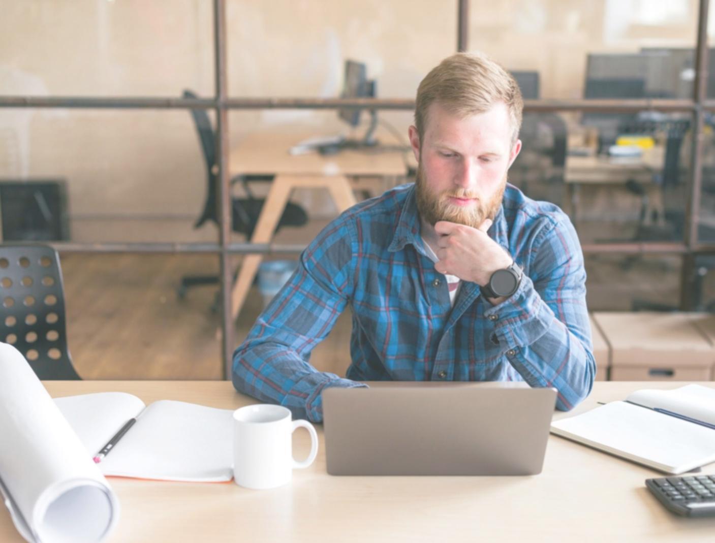 Business owner reviewing financial analysis on laptop with notes